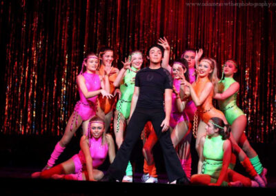 dancers in green, pink, and black outfits